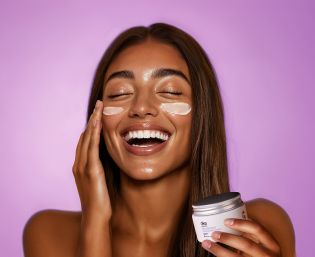 Chicas con crema facial aplicada sonriendo a c&aacute;mara